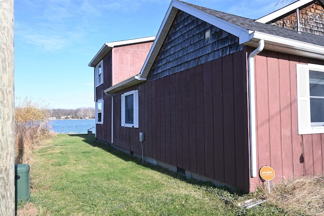 view of home's exterior featuring a yard and a water view