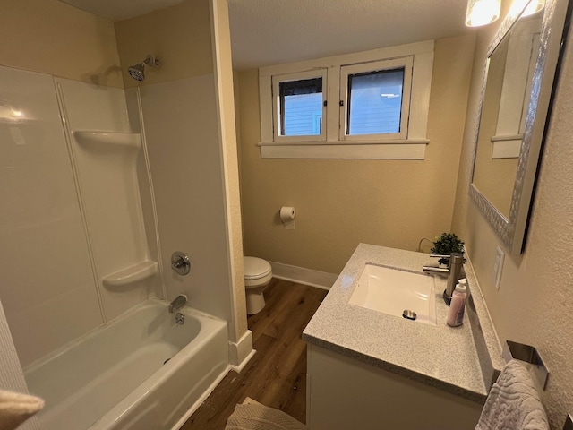 full bathroom with a textured ceiling, toilet, shower / washtub combination, vanity, and hardwood / wood-style flooring