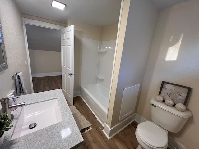 full bathroom featuring hardwood / wood-style flooring,  shower combination, toilet, and sink