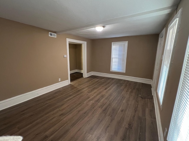 unfurnished room featuring dark hardwood / wood-style flooring and a textured ceiling