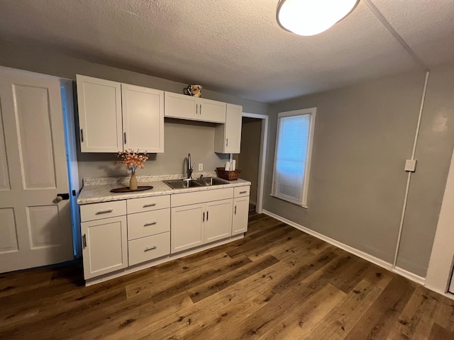 kitchen featuring white cabinetry, dark wood-type flooring, and sink