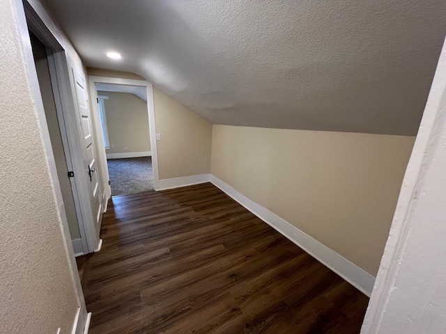 bonus room with lofted ceiling and dark wood-type flooring