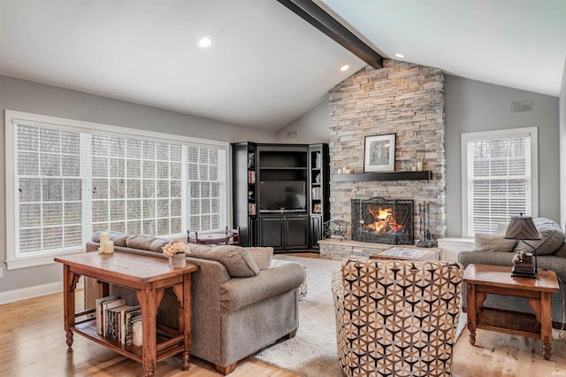 living room featuring a fireplace, lofted ceiling with beams, and light hardwood / wood-style flooring