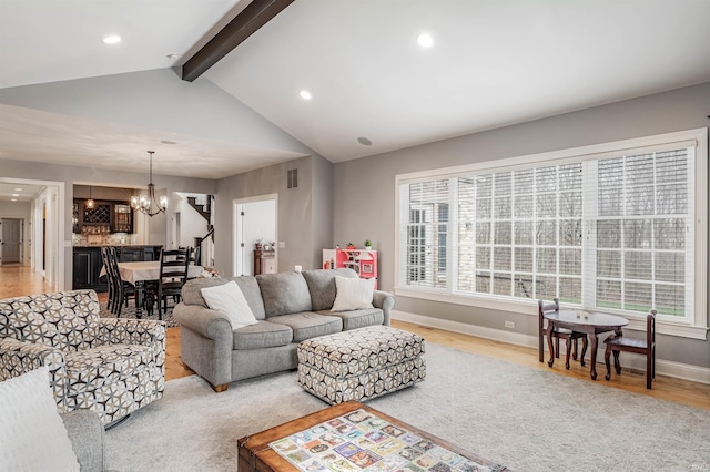 living room with vaulted ceiling with beams, an inviting chandelier, and light wood-type flooring