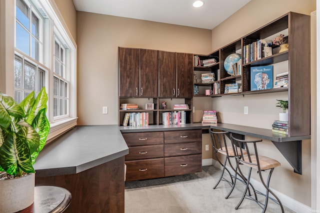 office space with light colored carpet and built in desk