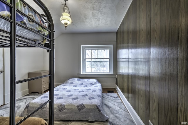 bedroom featuring a textured ceiling and lofted ceiling