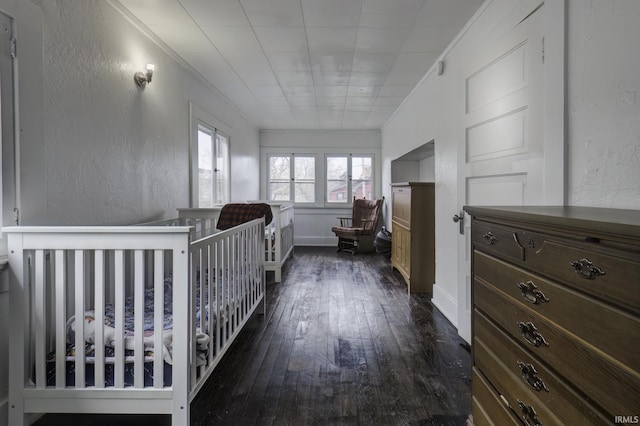 bedroom with dark hardwood / wood-style flooring and crown molding