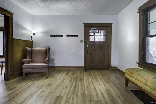 entrance foyer with light wood-type flooring and a textured ceiling