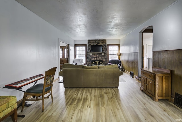 living room featuring wooden walls, a fireplace, and light hardwood / wood-style floors