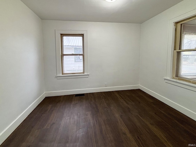 unfurnished room with dark wood-type flooring