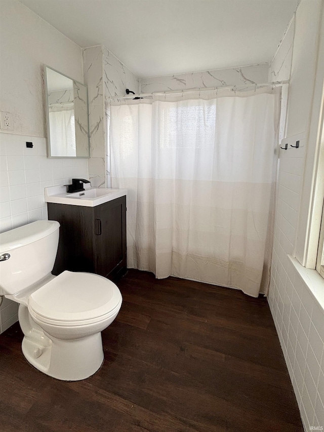 bathroom featuring tile walls, hardwood / wood-style floors, vanity, curtained shower, and toilet