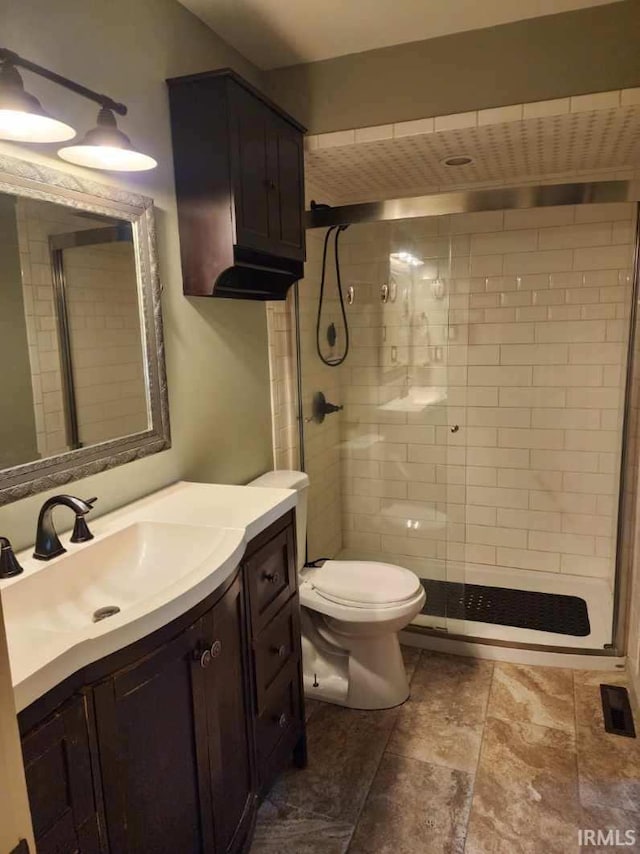 bathroom with toilet, vanity, and walk in shower