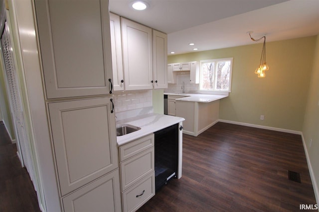 kitchen with sink, decorative backsplash, decorative light fixtures, dark hardwood / wood-style flooring, and white cabinetry