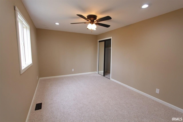 empty room featuring light carpet and ceiling fan