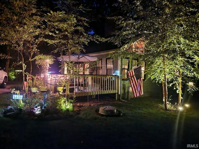 back house at twilight featuring a deck