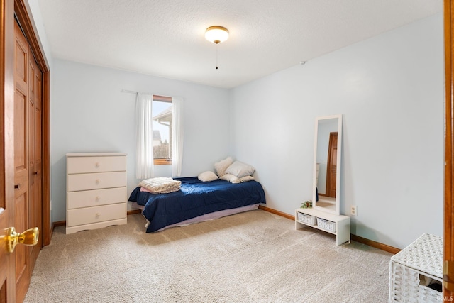 carpeted bedroom featuring a textured ceiling and a closet