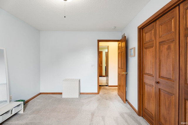 unfurnished bedroom featuring light carpet and a textured ceiling