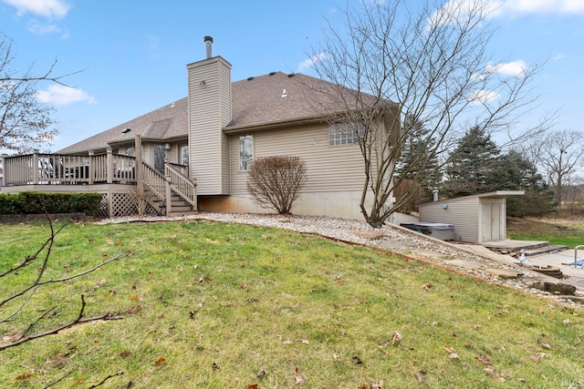 back of property with a yard, a shed, and a wooden deck