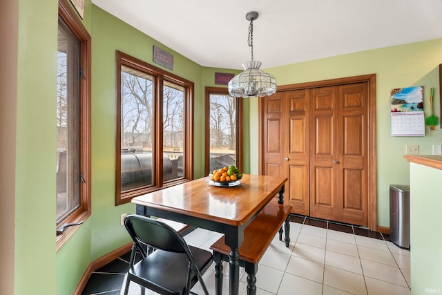 dining area with light tile patterned floors and an inviting chandelier