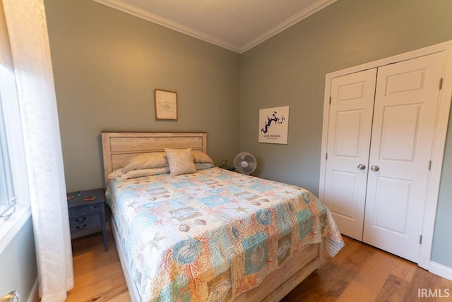 bedroom featuring crown molding, a closet, and light wood-type flooring