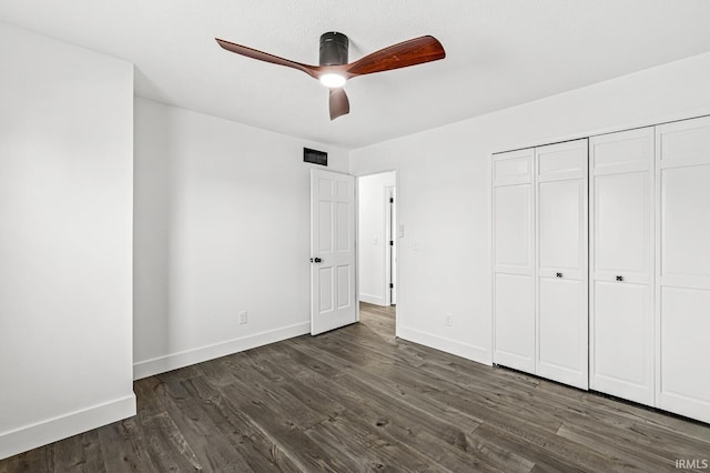 unfurnished bedroom featuring a closet, dark hardwood / wood-style floors, and ceiling fan