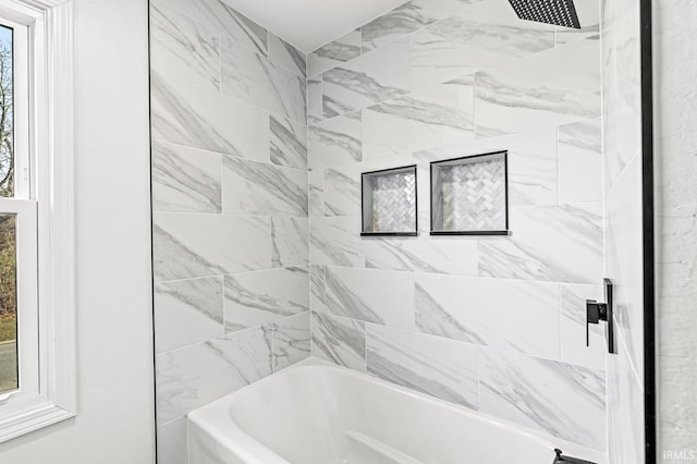 bathroom featuring tiled shower / bath