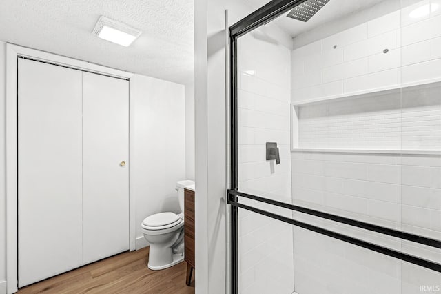 bathroom with vanity, hardwood / wood-style flooring, toilet, a textured ceiling, and an enclosed shower