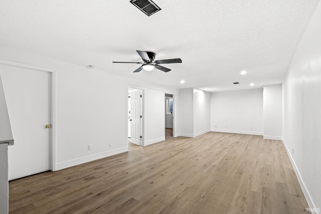 unfurnished room featuring ceiling fan, light hardwood / wood-style floors, and a textured ceiling