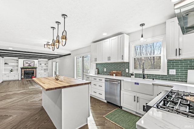 kitchen with white cabinets, butcher block countertops, and stainless steel dishwasher