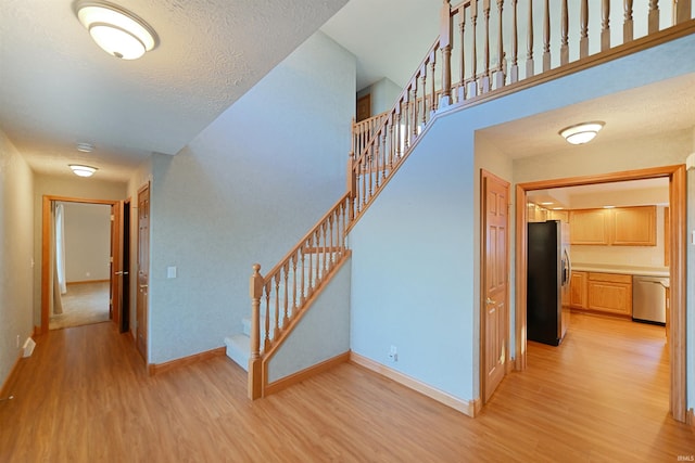 hallway featuring a textured ceiling and light wood-type flooring