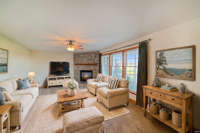 living room with a stone fireplace, ceiling fan, and wood-type flooring