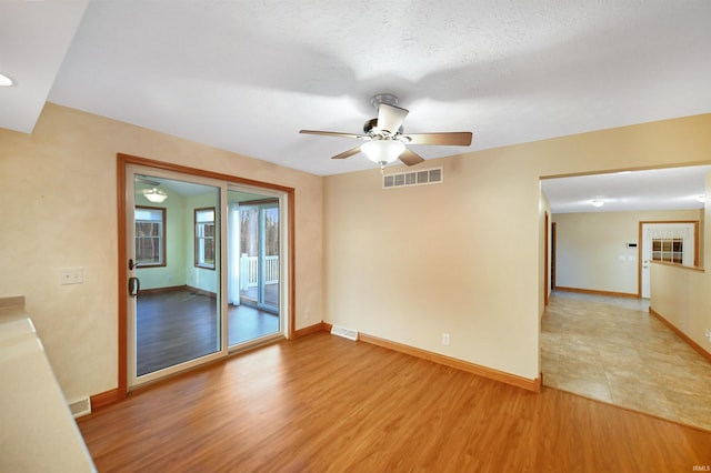 unfurnished room with hardwood / wood-style floors, a textured ceiling, and ceiling fan