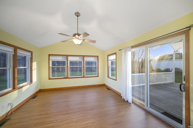 unfurnished sunroom featuring ceiling fan, a healthy amount of sunlight, and vaulted ceiling