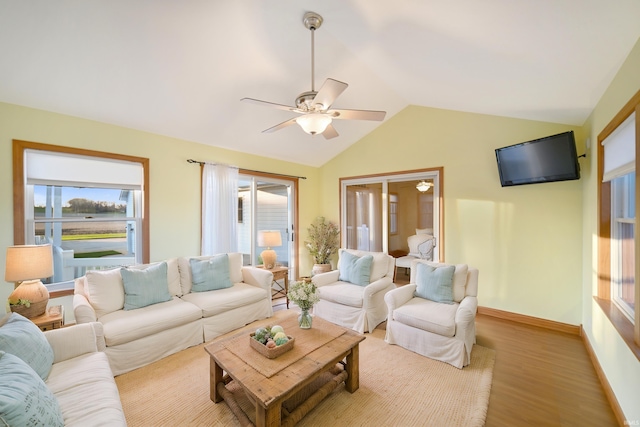 living room featuring light hardwood / wood-style flooring, a wealth of natural light, lofted ceiling, and ceiling fan