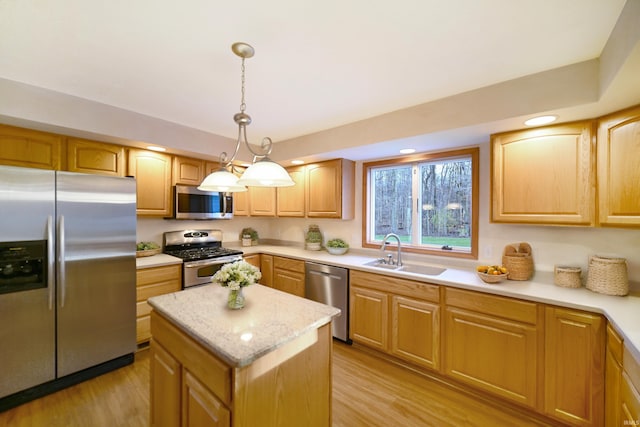 kitchen with decorative light fixtures, light wood-type flooring, sink, and appliances with stainless steel finishes