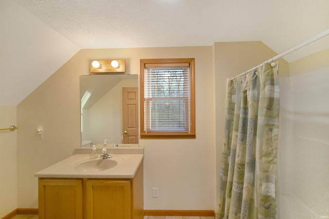 bathroom featuring a textured ceiling, curtained shower, vanity, and vaulted ceiling