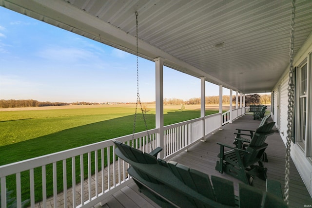 deck with a lawn, a rural view, and covered porch