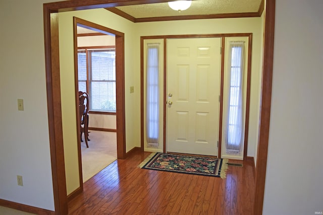 entryway with ornamental molding, a textured ceiling, and hardwood / wood-style flooring