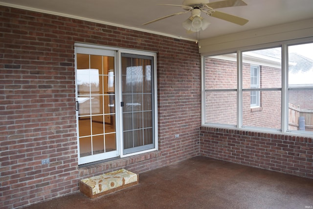 unfurnished sunroom featuring ceiling fan