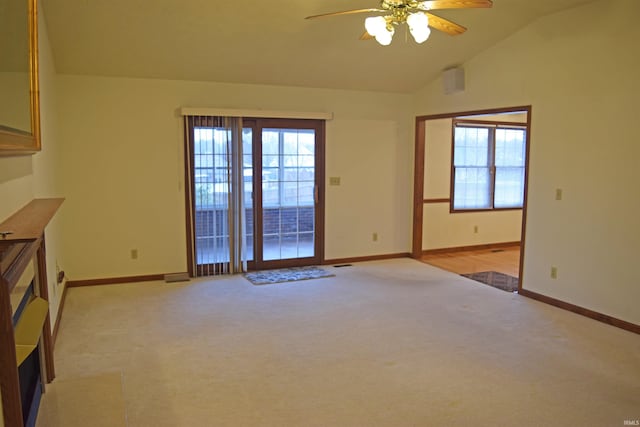 unfurnished living room with plenty of natural light, ceiling fan, lofted ceiling, and light carpet