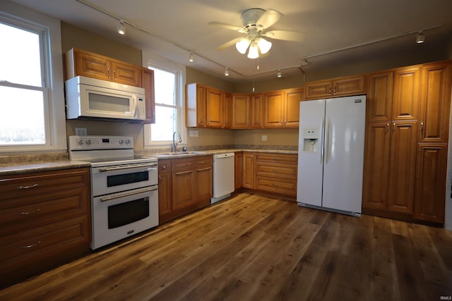 kitchen featuring white appliances, dark wood-type flooring, track lighting, sink, and ceiling fan