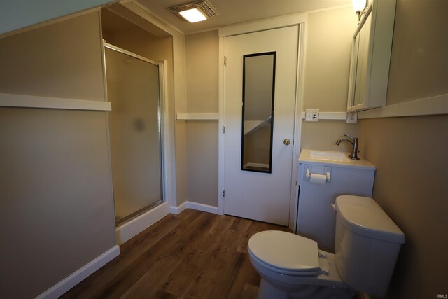 bathroom with toilet, sink, a shower with door, and hardwood / wood-style flooring