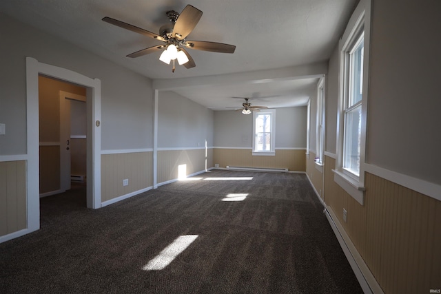 unfurnished room featuring ceiling fan, dark carpet, and a baseboard radiator
