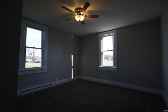 empty room with baseboard heating, ceiling fan, plenty of natural light, and dark colored carpet
