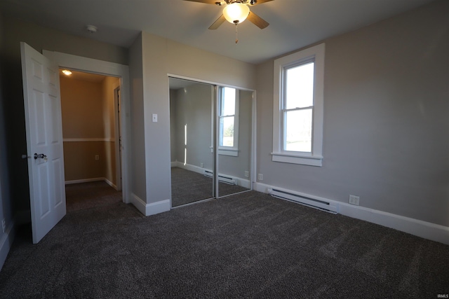 unfurnished bedroom with a closet, a baseboard radiator, dark carpet, and ceiling fan