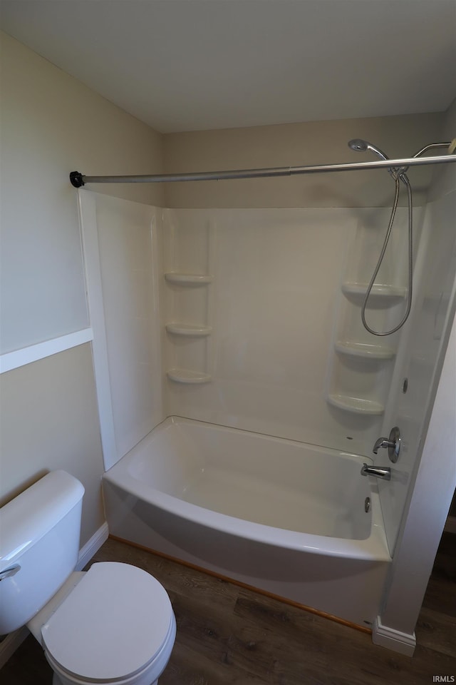 bathroom with hardwood / wood-style floors, shower / bathing tub combination, and toilet