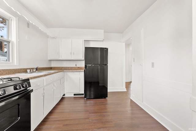 kitchen with white cabinets, dark hardwood / wood-style flooring, sink, and black appliances