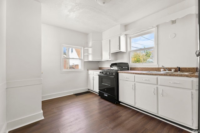 kitchen with black gas range, sink, dark wood-type flooring, a textured ceiling, and white cabinets