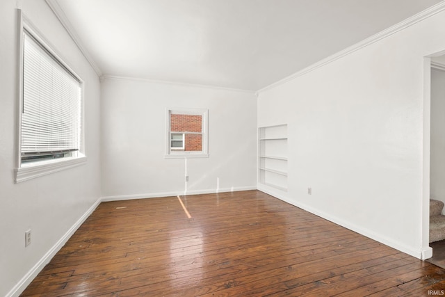 empty room with dark hardwood / wood-style floors and crown molding