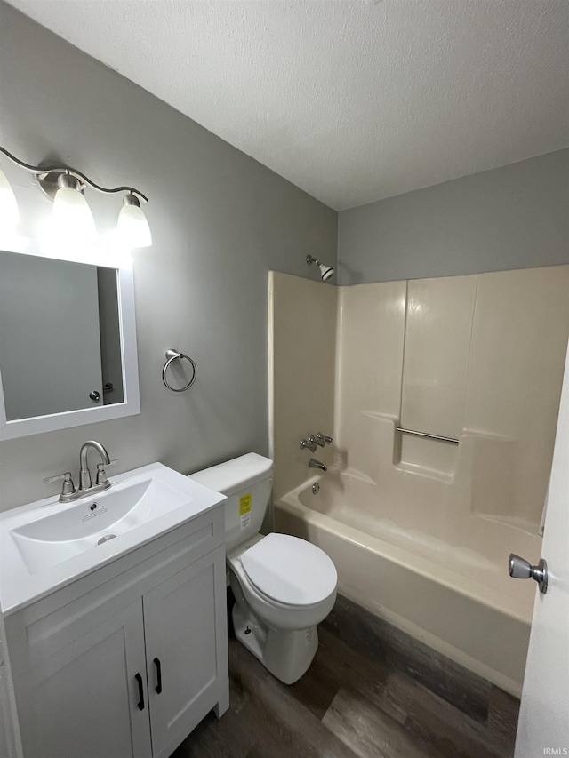 full bathroom with vanity, a textured ceiling, shower / tub combination, hardwood / wood-style flooring, and toilet